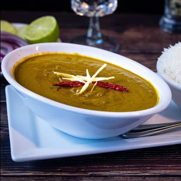 Amaravati Indian Cuisine's green curry with red chilies and ginger, served with rice and lime.